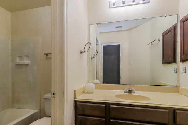 full bathroom featuring tiled shower / bath combo, vanity, and toilet