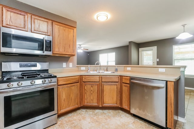 kitchen featuring light tile patterned floors, kitchen peninsula, ceiling fan, stainless steel appliances, and sink