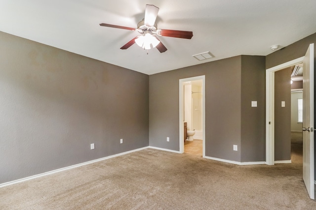 unfurnished bedroom with connected bathroom, light colored carpet, and ceiling fan