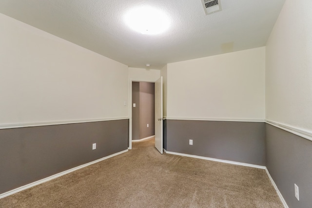 empty room with carpet floors and a textured ceiling