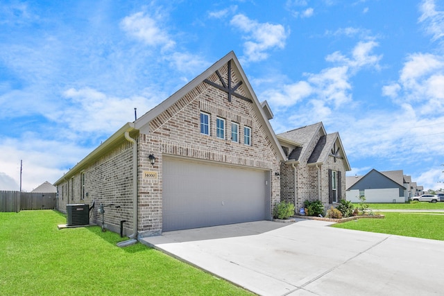 view of front of home featuring a garage, cooling unit, and a front yard