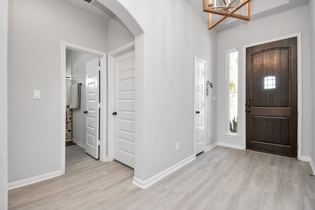 foyer with light hardwood / wood-style floors and a notable chandelier