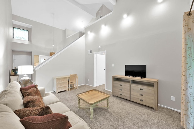 carpeted living room with high vaulted ceiling