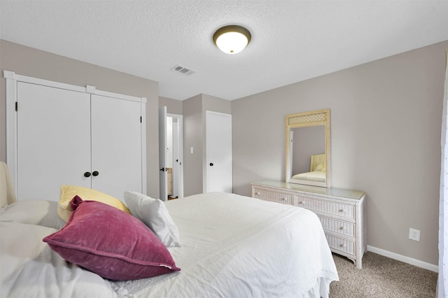 carpeted bedroom featuring a closet and a textured ceiling