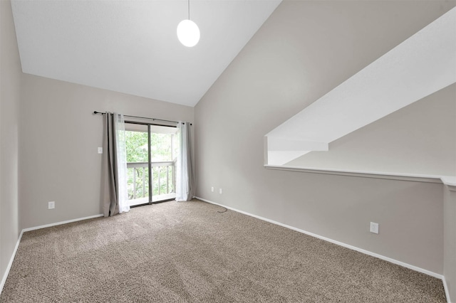 carpeted spare room featuring high vaulted ceiling