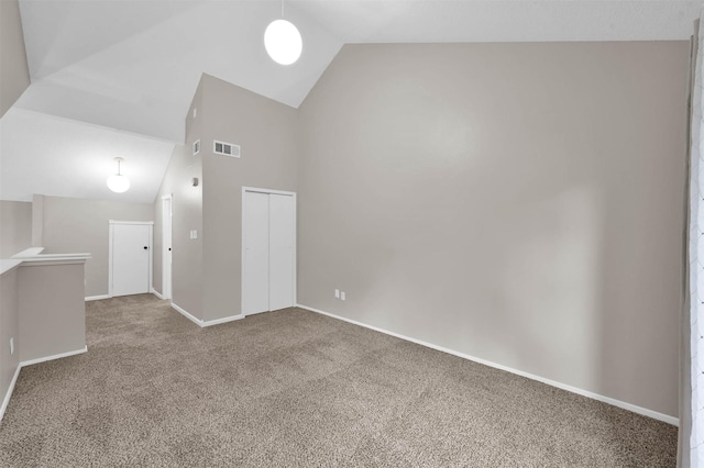 empty room featuring carpet and high vaulted ceiling