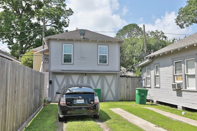 exterior space with a garage, a yard, and cooling unit