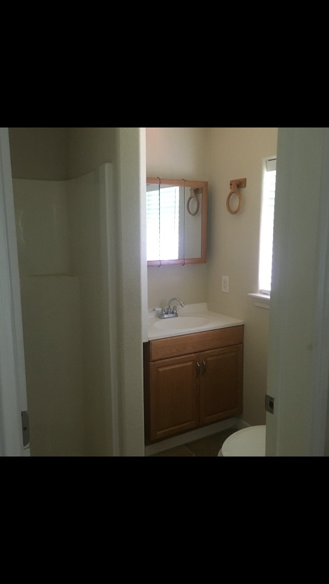 bathroom featuring vanity, tile patterned floors, and toilet