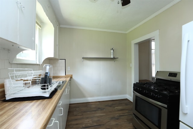 kitchen with stainless steel range with gas cooktop, white cabinets, butcher block countertops, dark hardwood / wood-style floors, and backsplash