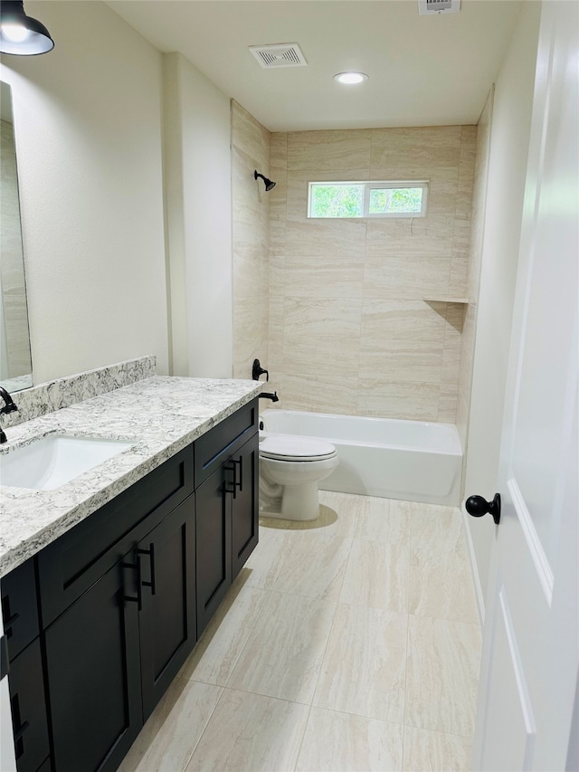 full bathroom with tiled shower / bath combo, vanity, tile patterned floors, and toilet