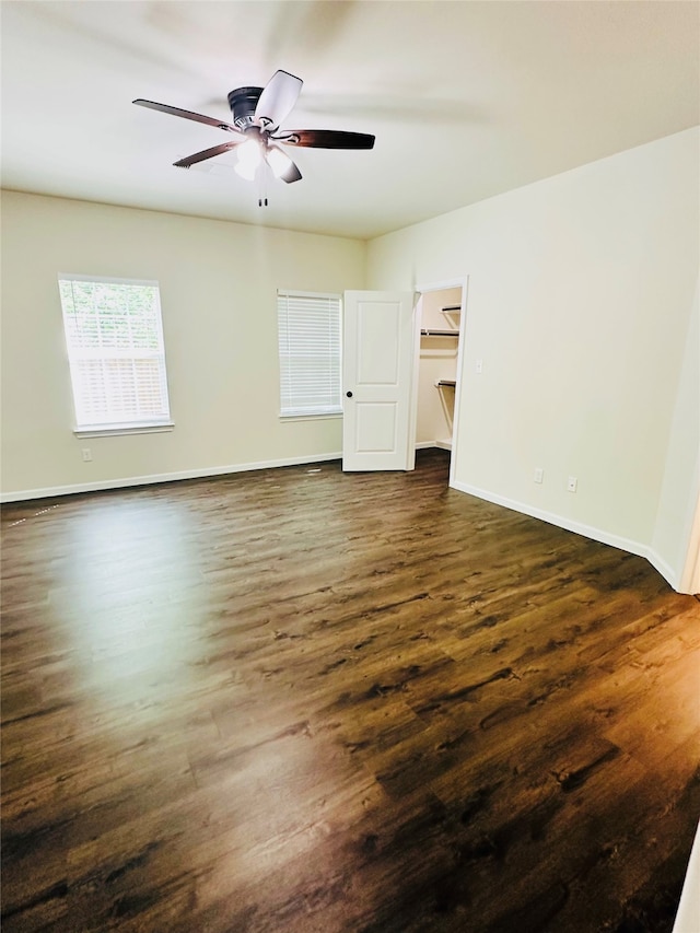 unfurnished room featuring dark wood-type flooring and ceiling fan