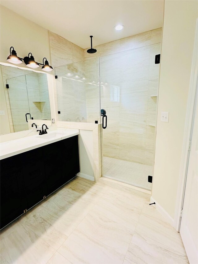 bathroom with a shower with shower door, vanity, and tile patterned flooring