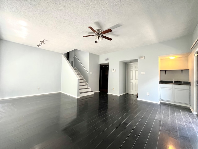 unfurnished living room featuring hardwood / wood-style flooring, a textured ceiling, and ceiling fan