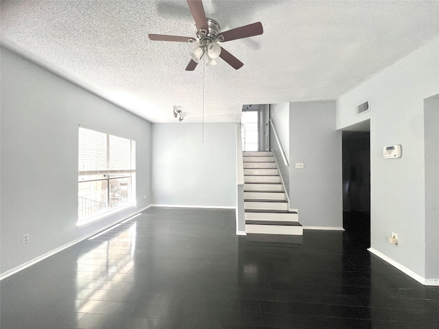 interior space with dark wood-type flooring, a textured ceiling, and ceiling fan