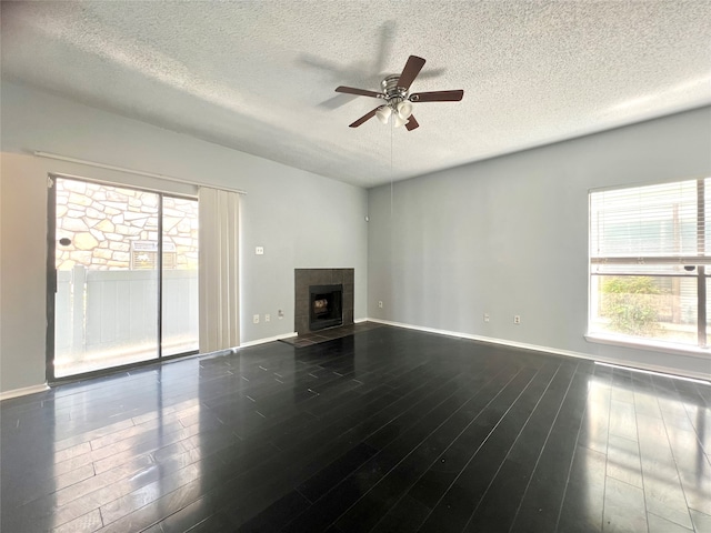 unfurnished living room with a textured ceiling, a fireplace, and hardwood / wood-style floors