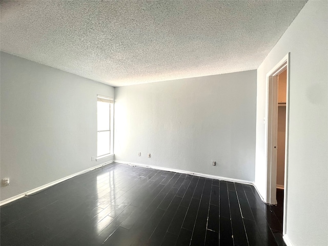 unfurnished room featuring hardwood / wood-style floors and a textured ceiling