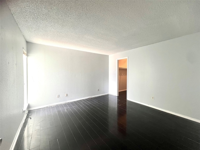 unfurnished room featuring hardwood / wood-style flooring and a textured ceiling