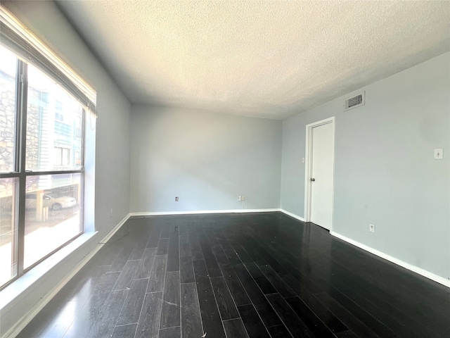 empty room featuring wood-type flooring and a textured ceiling