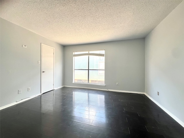 unfurnished room with a textured ceiling