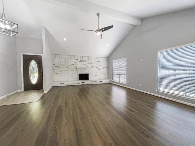 unfurnished living room with high vaulted ceiling, dark hardwood / wood-style flooring, a brick fireplace, ceiling fan with notable chandelier, and beamed ceiling