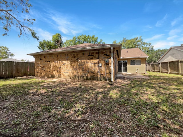 back of house featuring a patio and a yard