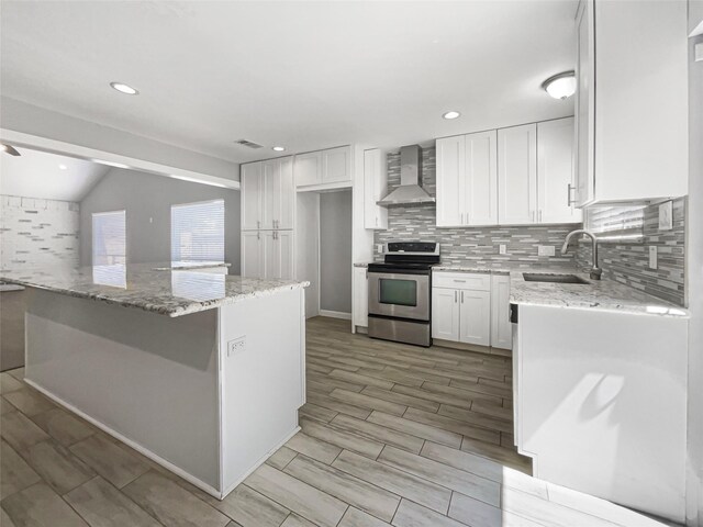 kitchen with sink, wall chimney range hood, white cabinetry, light stone countertops, and stainless steel electric stove