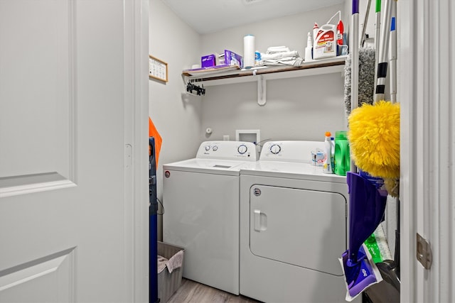 laundry area featuring separate washer and dryer and light hardwood / wood-style floors