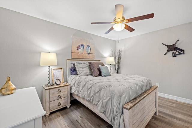 bedroom with dark hardwood / wood-style flooring and ceiling fan