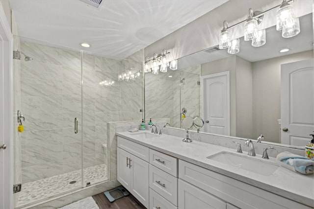 bathroom with double vanity, hardwood / wood-style floors, and an enclosed shower