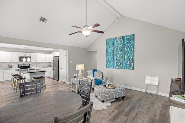 interior space featuring hardwood / wood-style flooring, high vaulted ceiling, sink, and ceiling fan