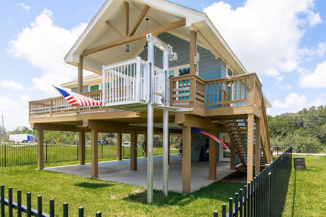 back of property with a wooden deck, a patio, and a lawn