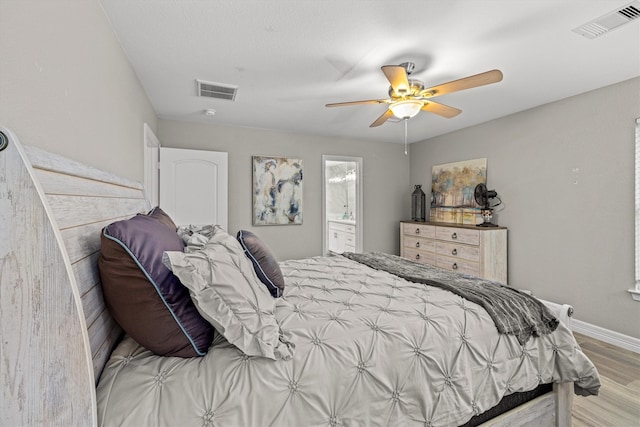 bedroom with ensuite bath, light wood-type flooring, and ceiling fan