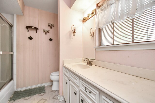 full bathroom featuring vanity, toilet, combined bath / shower with glass door, and tile patterned flooring