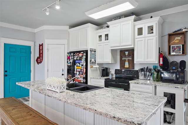 kitchen with a kitchen bar, black appliances, sink, a kitchen island with sink, and white cabinetry