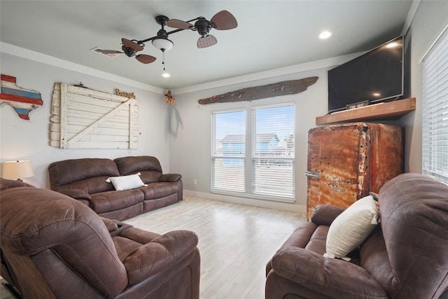 living room featuring ornamental molding, light wood-type flooring, and ceiling fan