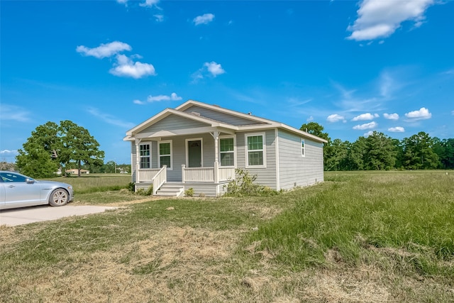 view of front of home with covered porch and a front lawn