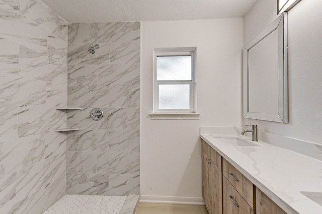 bathroom featuring a tile shower and vanity