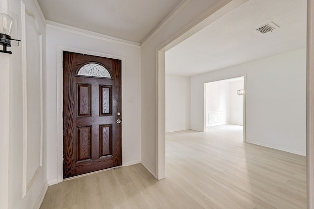 foyer entrance with light wood-type flooring and crown molding