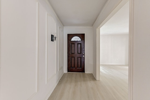 entryway featuring light wood-type flooring and crown molding