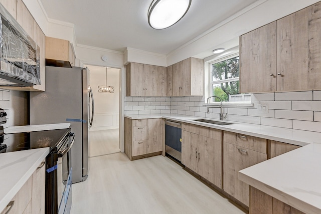 kitchen with light wood-type flooring, sink, decorative backsplash, appliances with stainless steel finishes, and ornamental molding