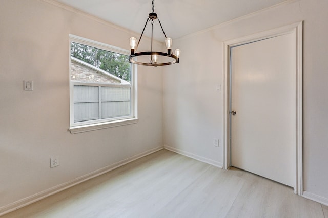 unfurnished dining area with crown molding, light hardwood / wood-style floors, and a chandelier