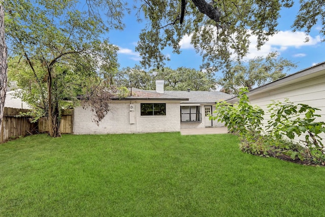 rear view of property featuring a patio area and a yard