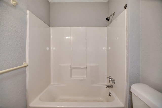 bathroom featuring shower / washtub combination and toilet