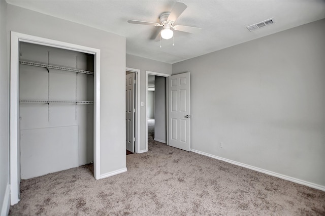 unfurnished bedroom featuring ceiling fan, a closet, and light carpet