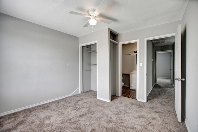 unfurnished bedroom with ensuite bath, ceiling fan, a textured ceiling, light carpet, and a closet