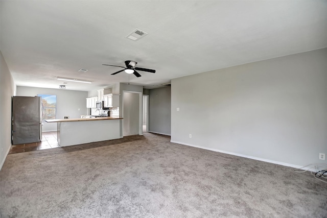 unfurnished living room with light carpet and ceiling fan