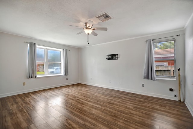 empty room with crown molding, plenty of natural light, dark wood-type flooring, and ceiling fan