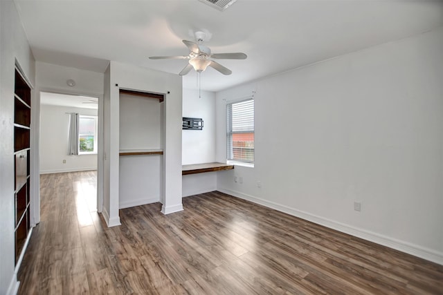 unfurnished room featuring ceiling fan, dark hardwood / wood-style floors, and a healthy amount of sunlight