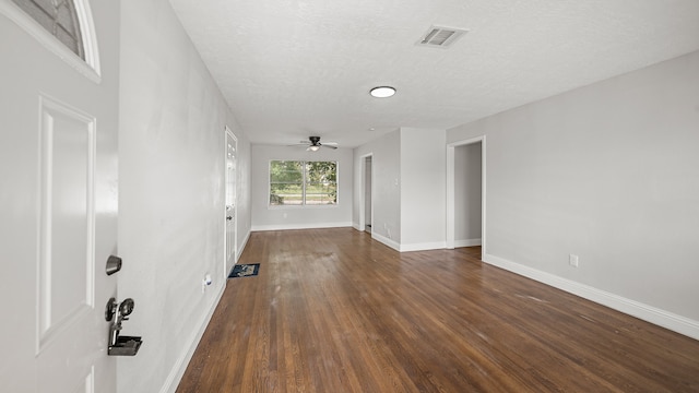 spare room with dark hardwood / wood-style floors, a textured ceiling, and ceiling fan