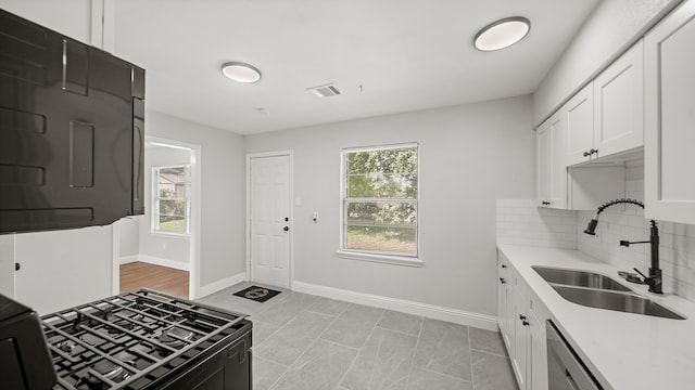 kitchen with tasteful backsplash, sink, and white cabinets